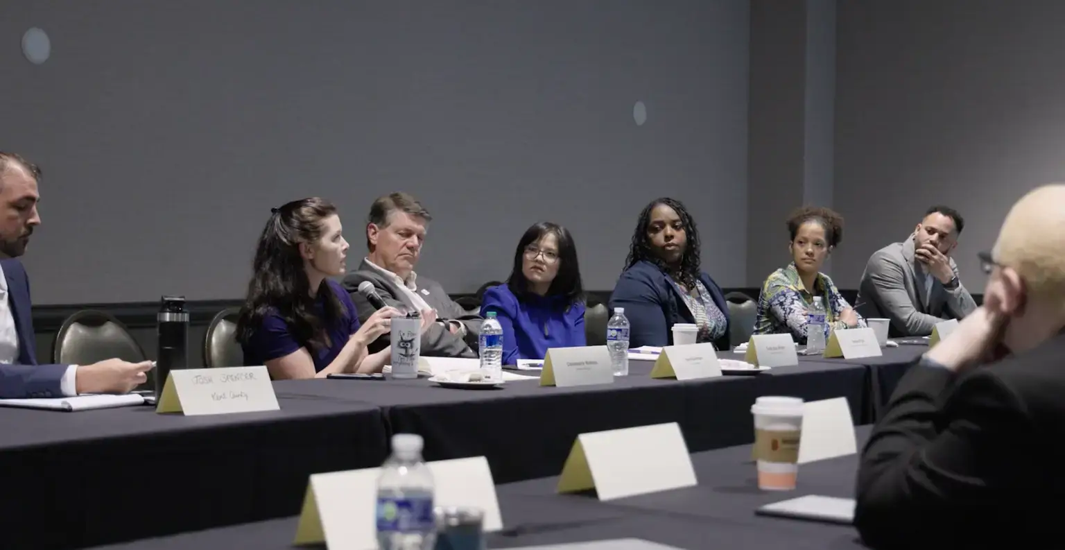 Community members gather at a conference table, collaborating to advance shared goals in an inclusive, focused setting.